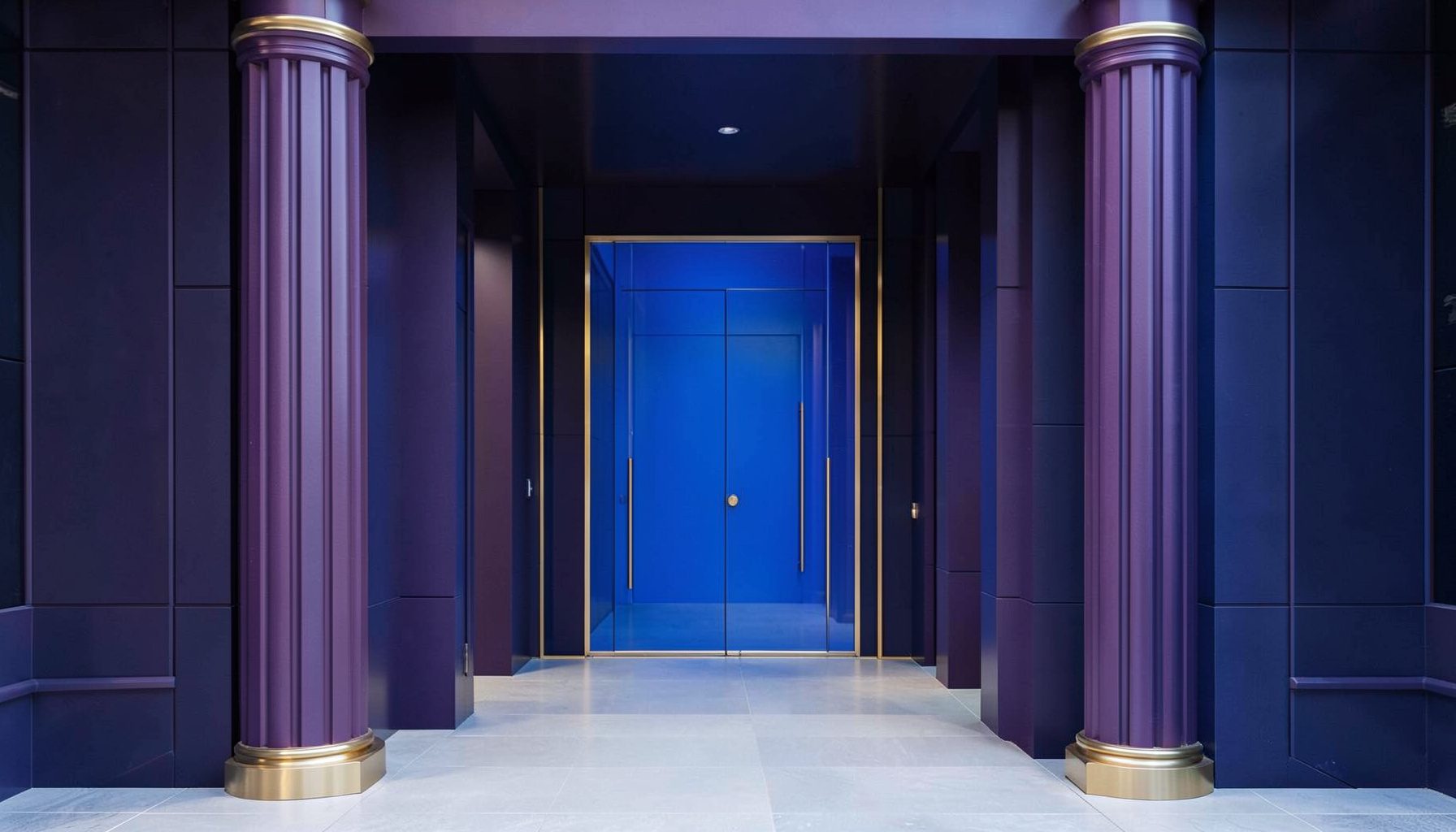 Illustrazione simmetrica di un ingresso architettonico moderno con colonne in tonalità viola scuro e blu, dettagli dorati e atmosfera elegante e ordinata